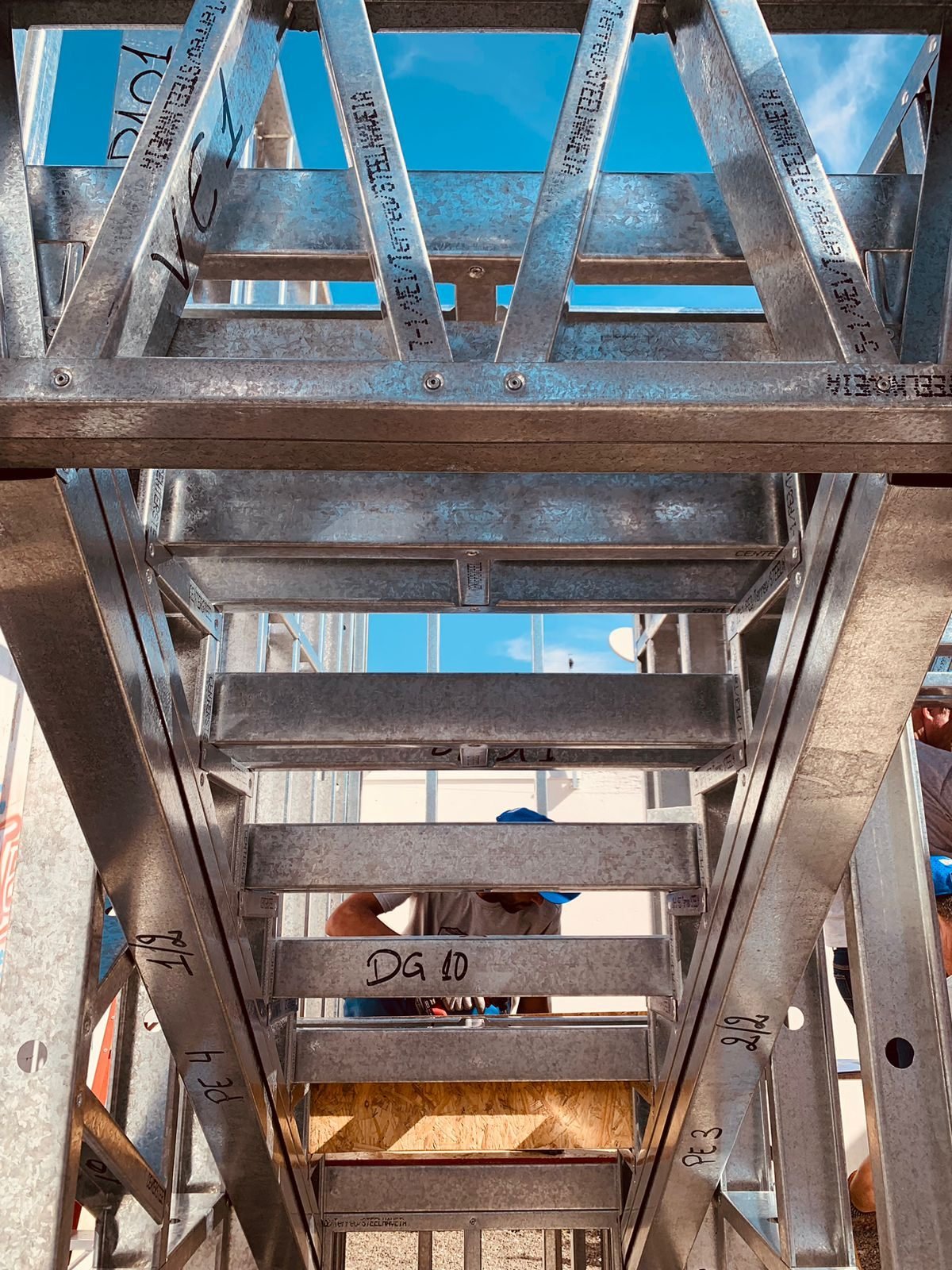Perfis galvanizados de light steel frame com marcações de montagem, vistos de baixo